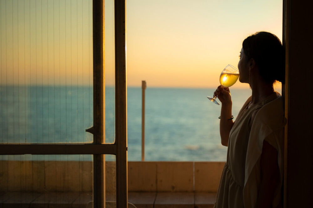 夕焼けのカフェに立つ女性